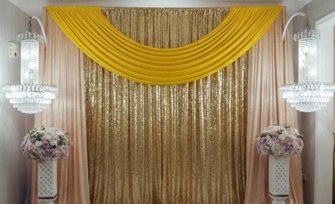 Gold sequin backdrop with yellow draping