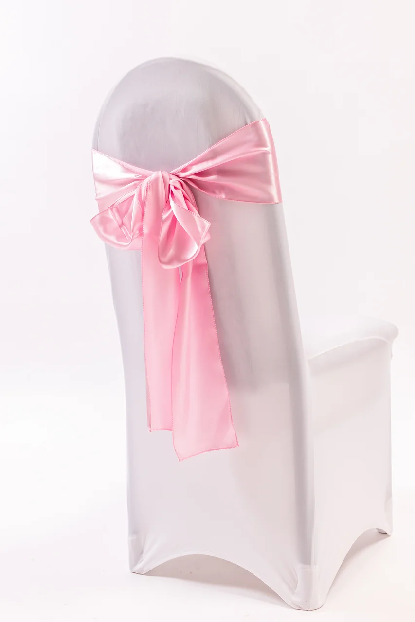 Pink chair sash tied in a bow on a white covered chair