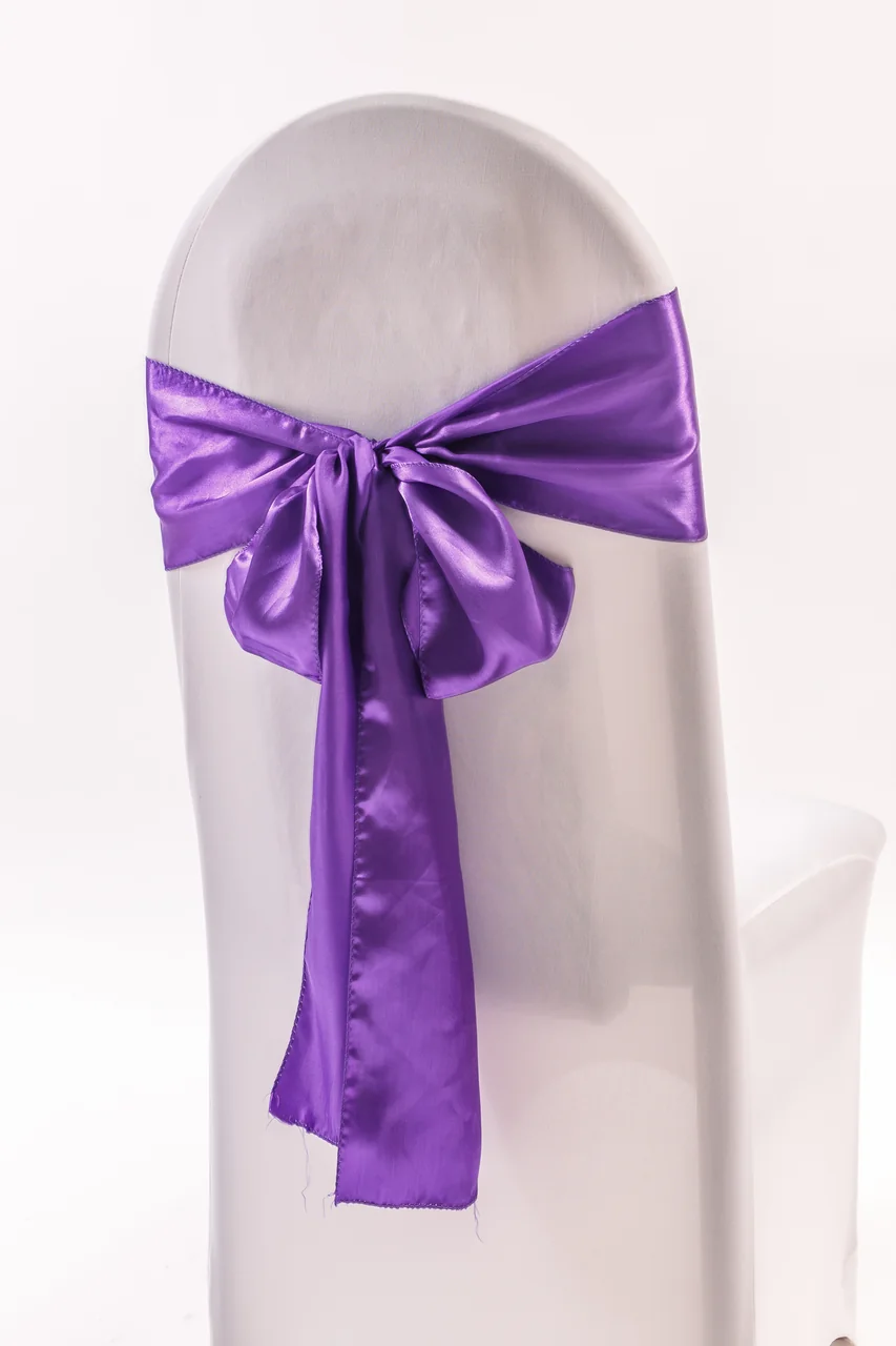Purple chair sash tied in a bow on a white covered chair