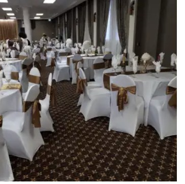 Ballroom set with white chair covers and gold sashes