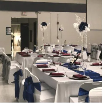 Reception tables styled with navy sashes and tall centerpieces